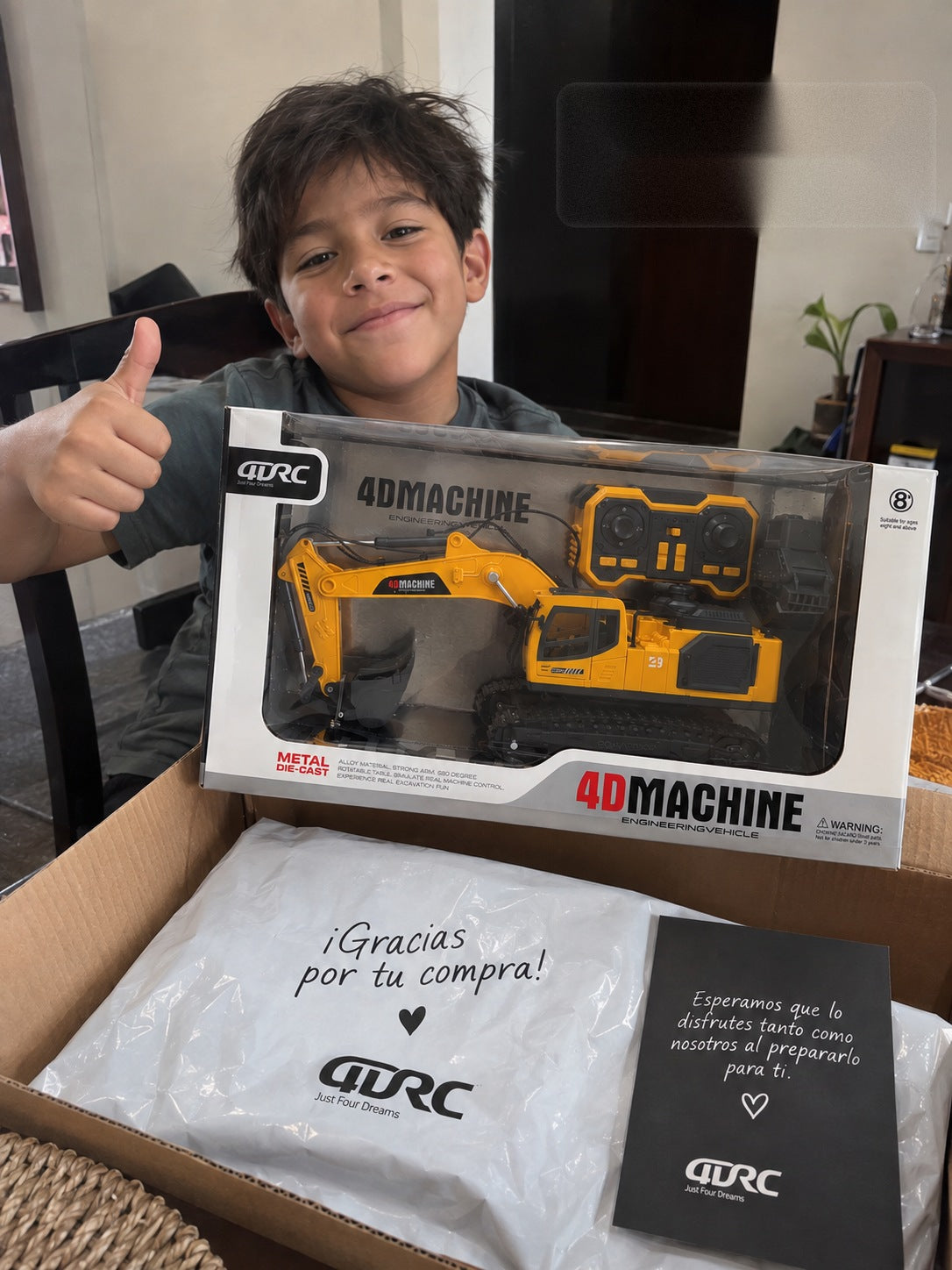 Niño sonriendo con la caja de su excavadora RC